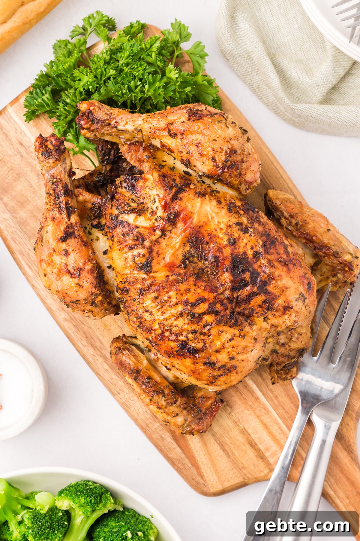 Cooked Whole Chicken on wooden serving board.