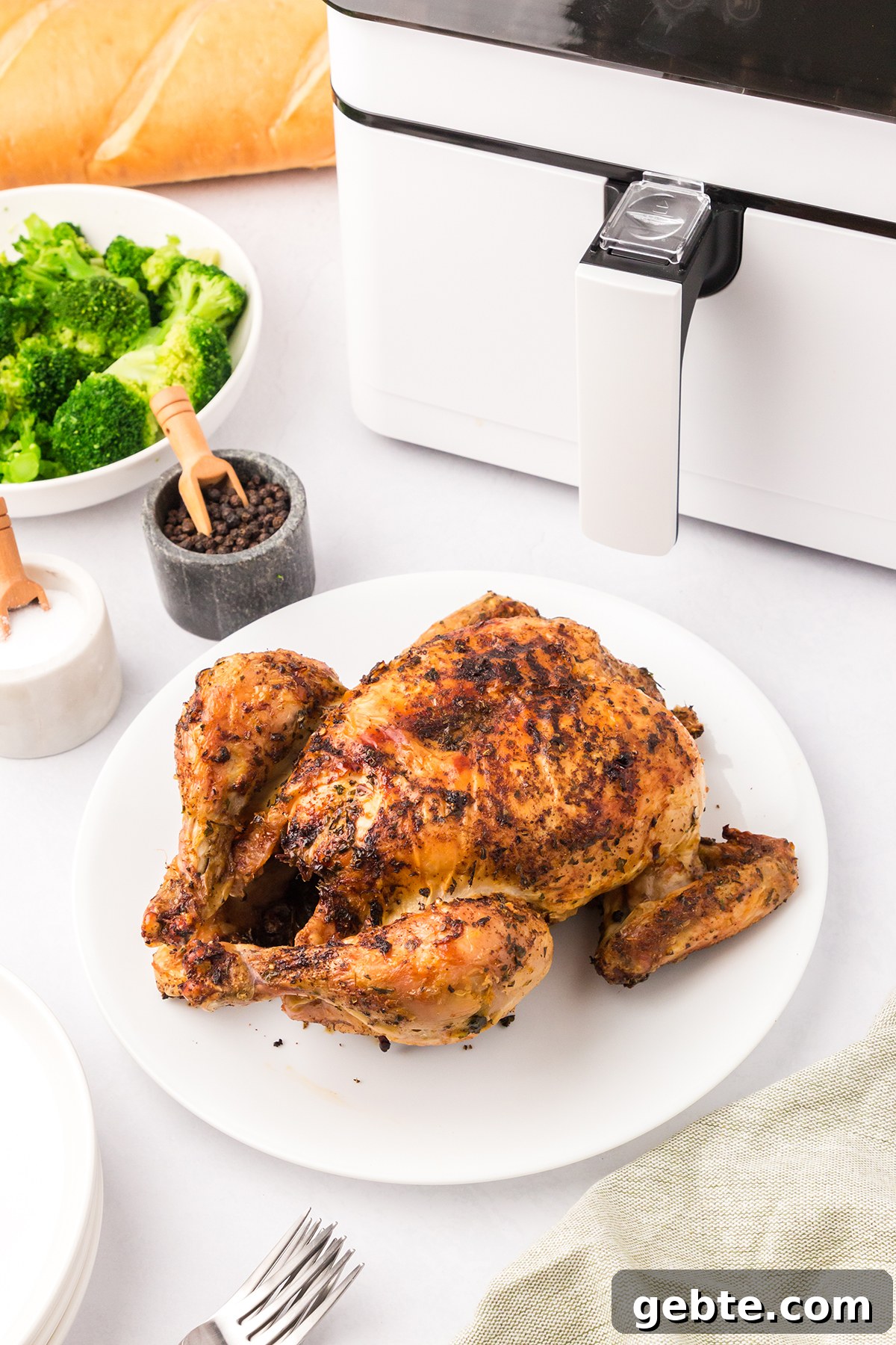 Whole Chicken on white serving plate.