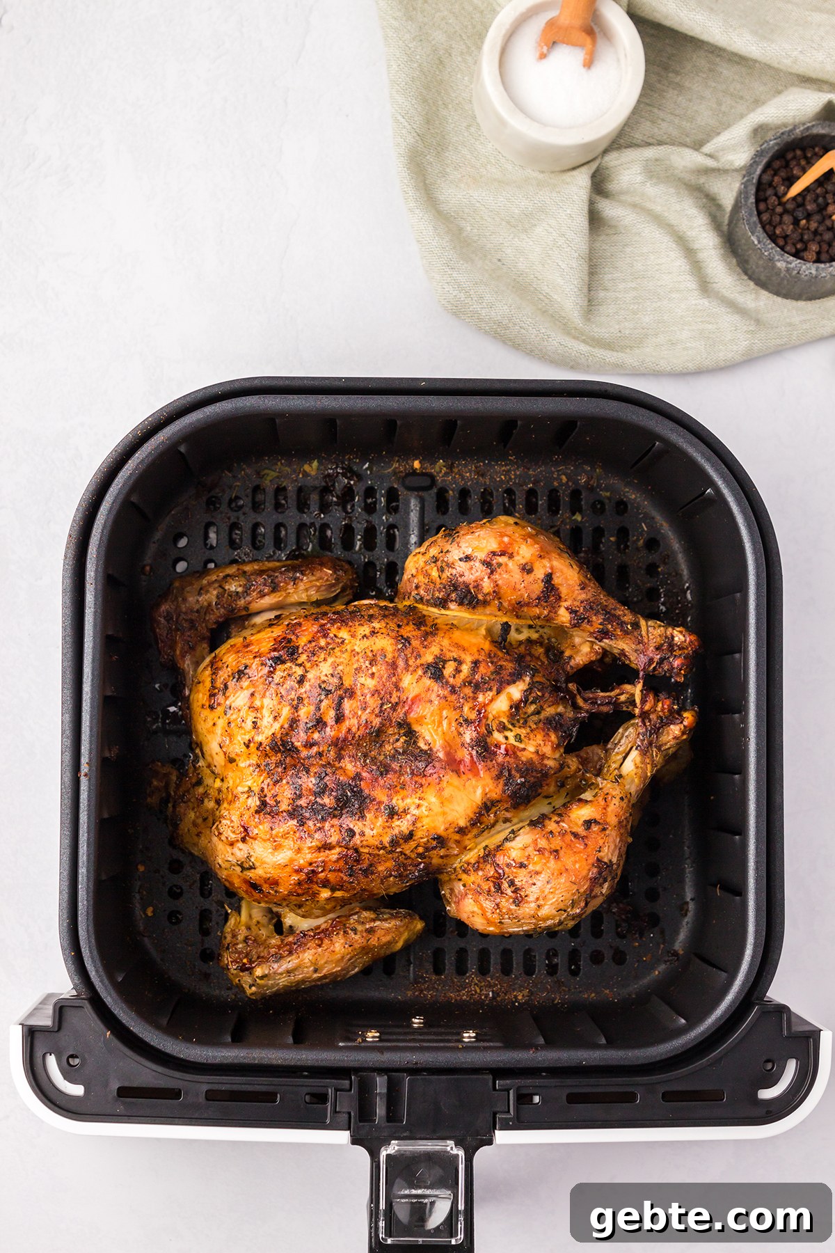 Cooked Whole Chicken in air fryer basket.
