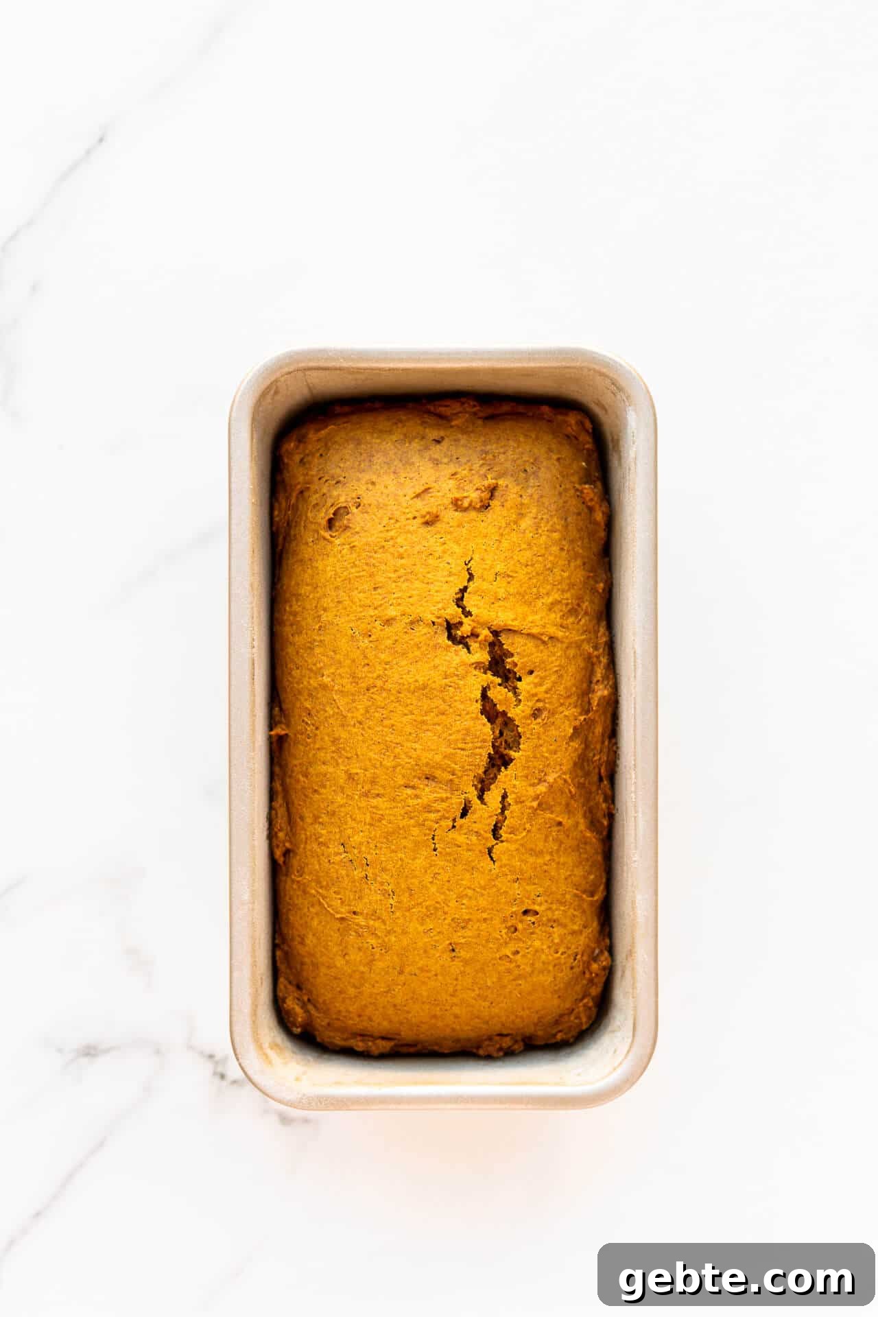 Freshly baked eggless pumpkin bread cooling in the loaf pan it was baked in