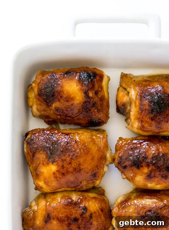 Honey Mustard Chicken Thighs | chefsavvy.com Top down 6 crispy honey baked chicken thighs in a white baking dish.