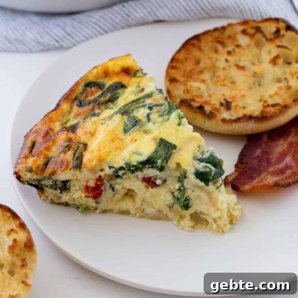 Green Chile Egg White Frittata 7 Slice of crustless quiche on a plate with english muffin and bacon.