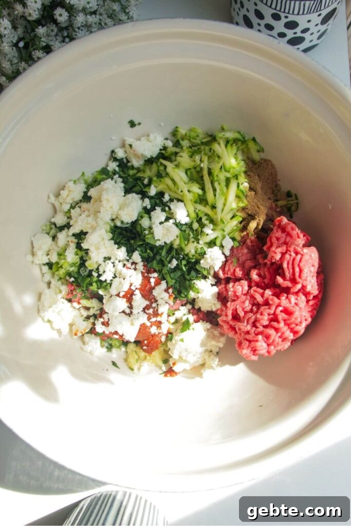 Ingredients for harissa, feta and zucchini meatballs in a large mixing bowl.