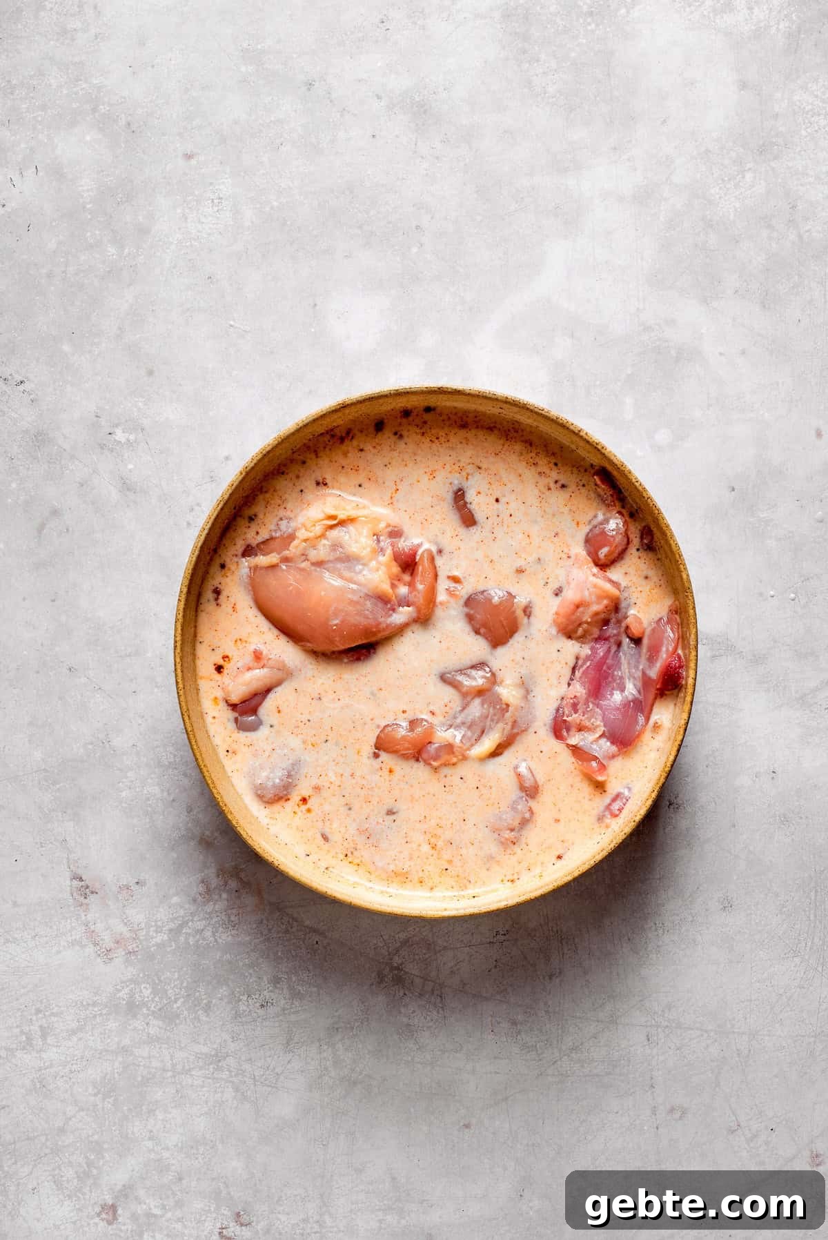 Chicken thighs marinate in buttermilk.