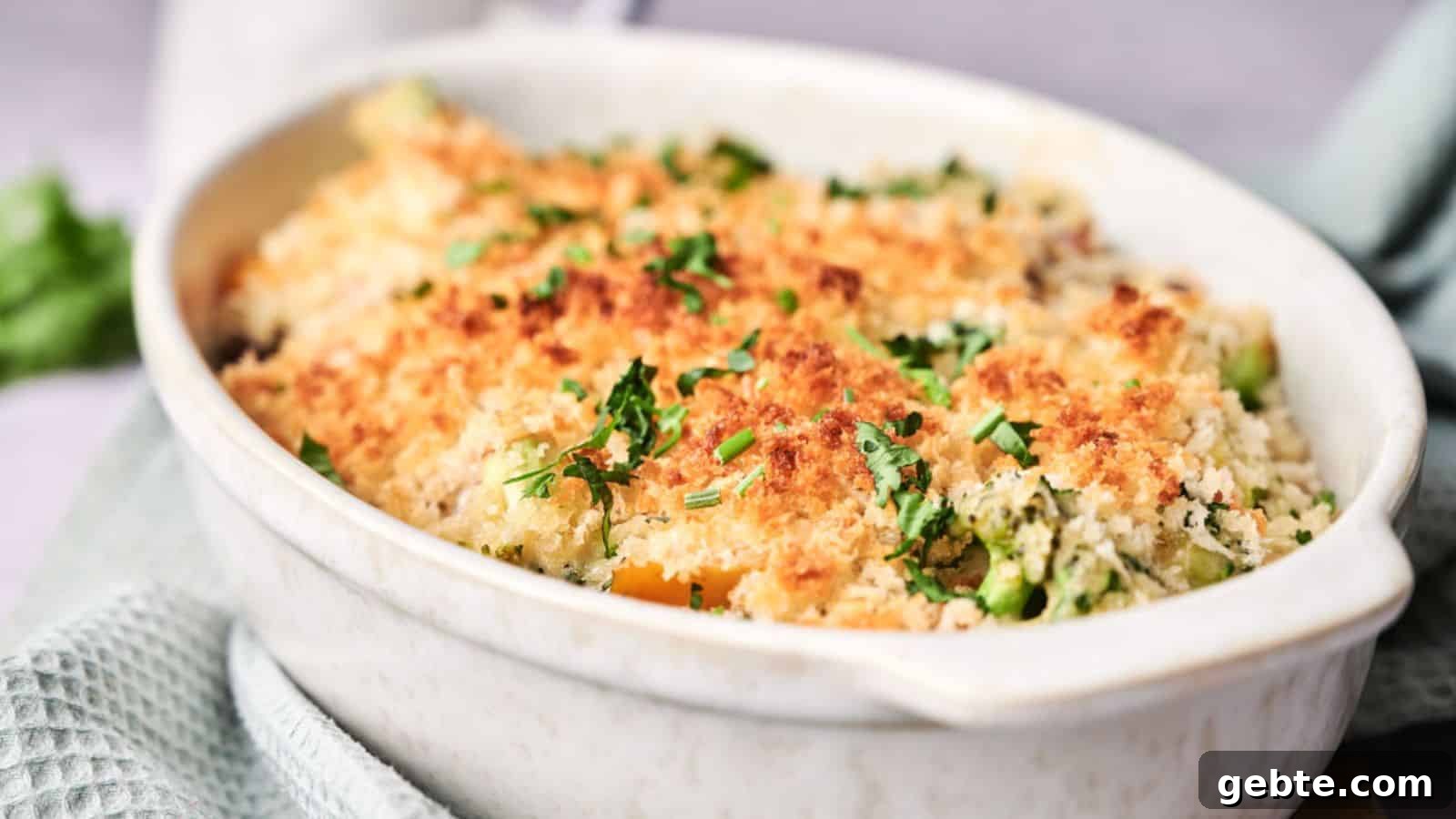 A baked casserole with a golden breadcrumb topping, garnished with fresh herbs.