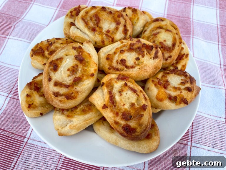 Overhead view of round pepperoni pinwheels with layers of cheese and pepperoni rolled up in refrigerated dough