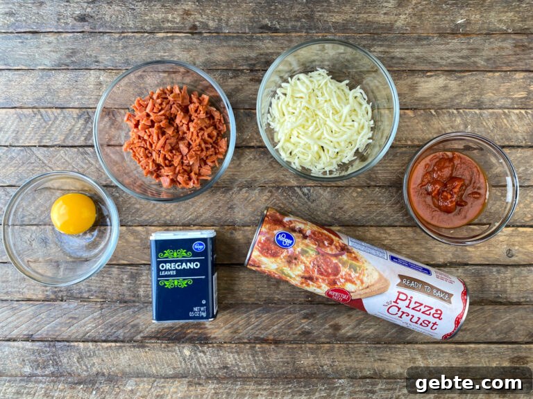 Ingredients to make pepperoni pinwheels are an egg, chopped pepperoni, mozzarella cheese, pizza sauce, oregano and a roll of refrigerated pizza crust.