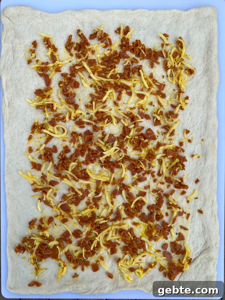 Pepperoni, shredded mozzarella cheese, oregano and egg yolk spread over a rectangular layer of refrigerated pizza dough