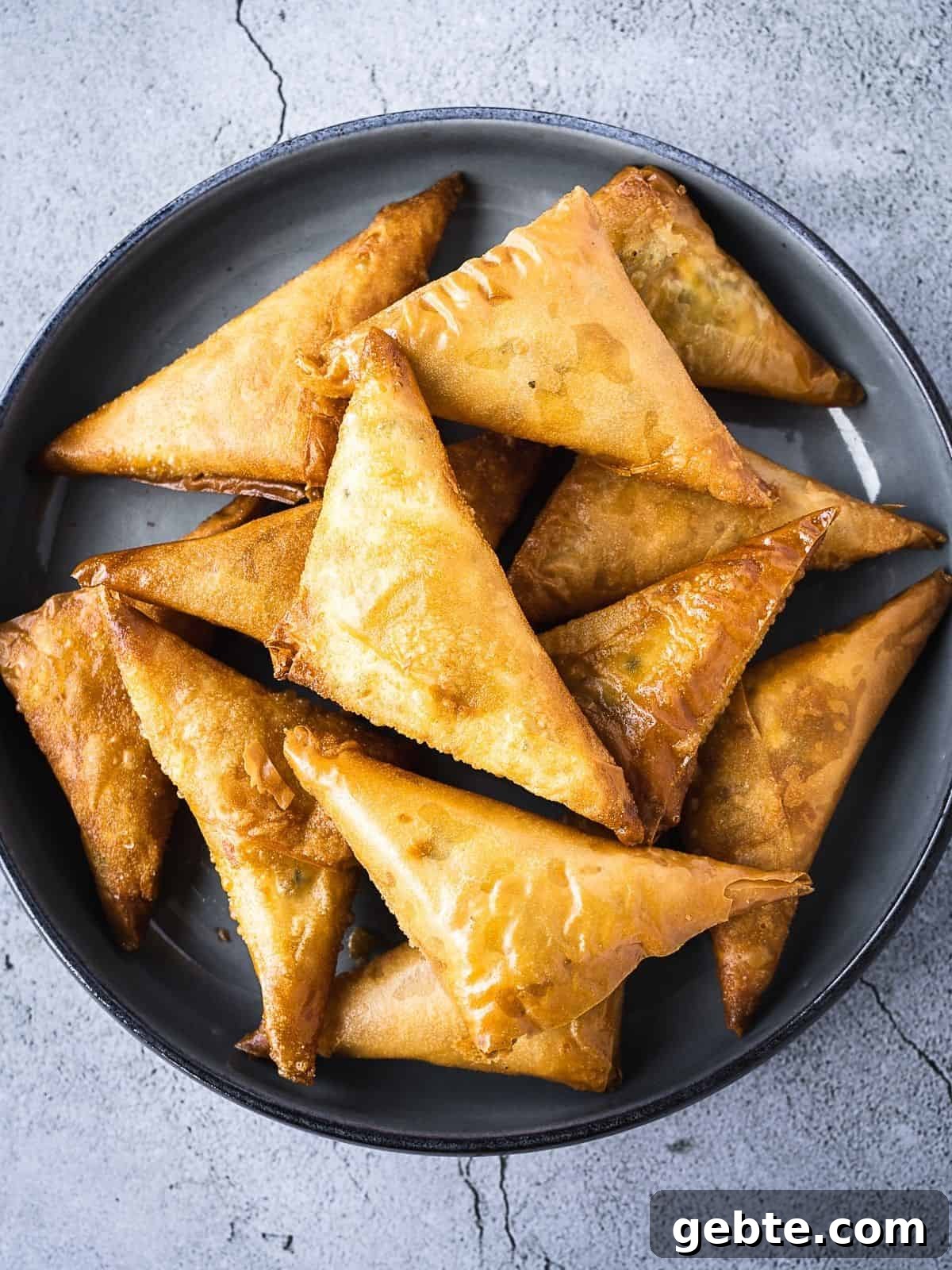 Crispy Cheese Sambousek: Middle Eastern Fried Pastries 2 Deep fried pastries in a bowl.
