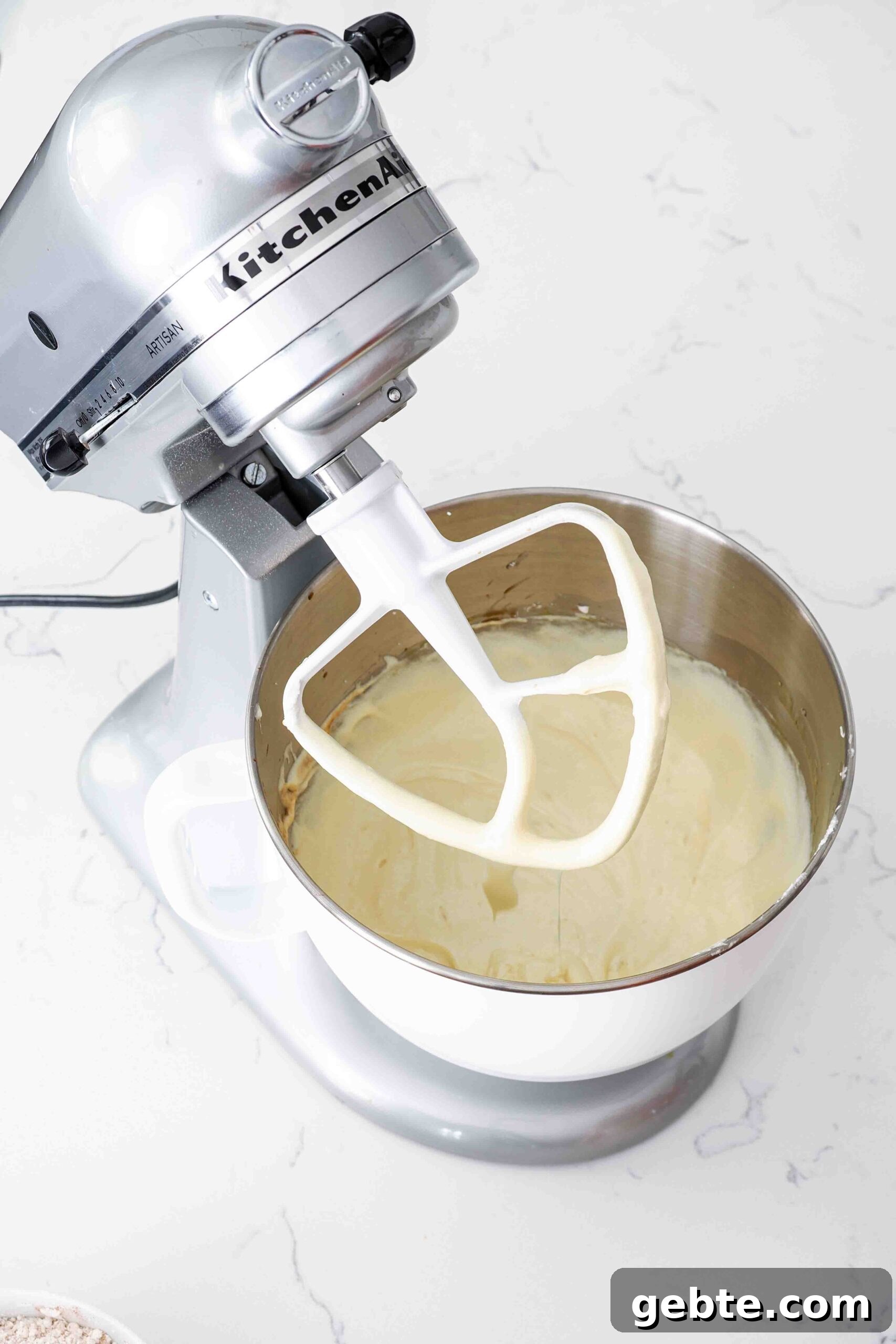 Butter, sugar, and eggs creamed together in a stand mixer bowl.