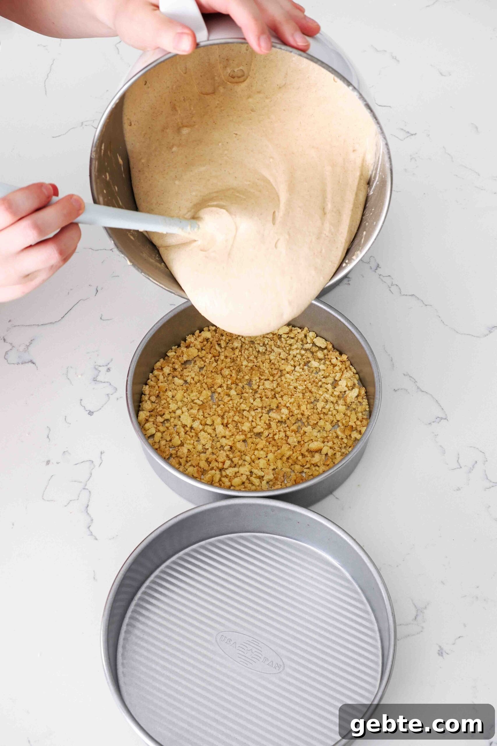 Cinnamon cake batter is poured into 8-inch cake pans.