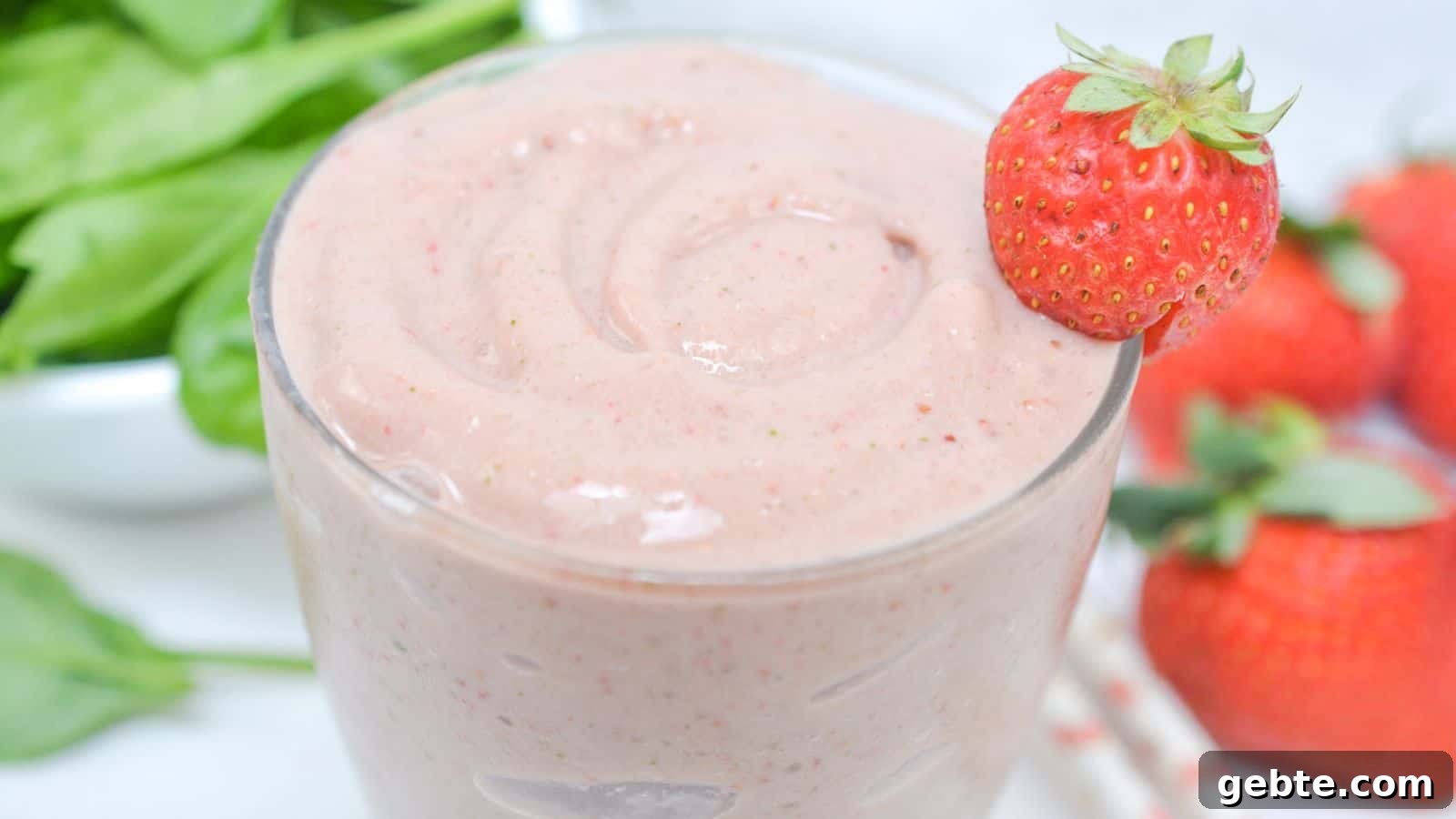 Side view of spinach strawberry smoothie in glass.