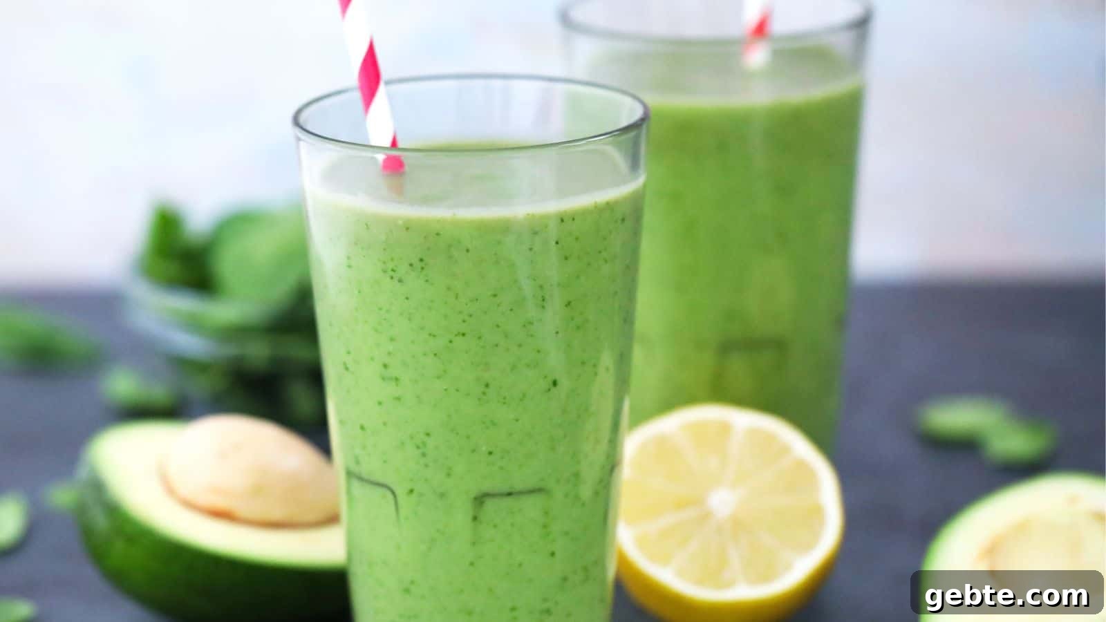 Two tall glasses of avocado spinach smoothie.