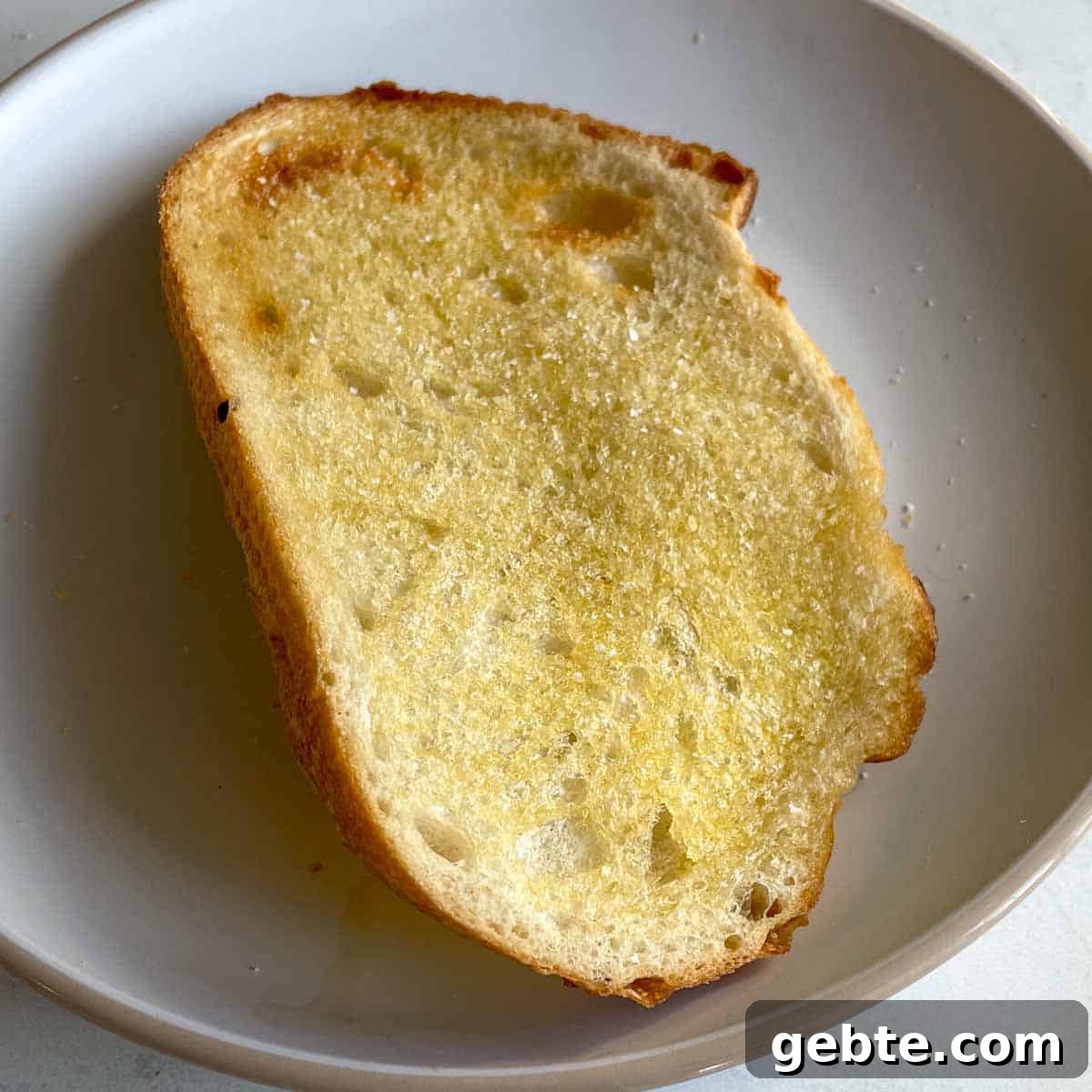 Image shows a closeup of a piece of toast that has been sprinkled with salt.