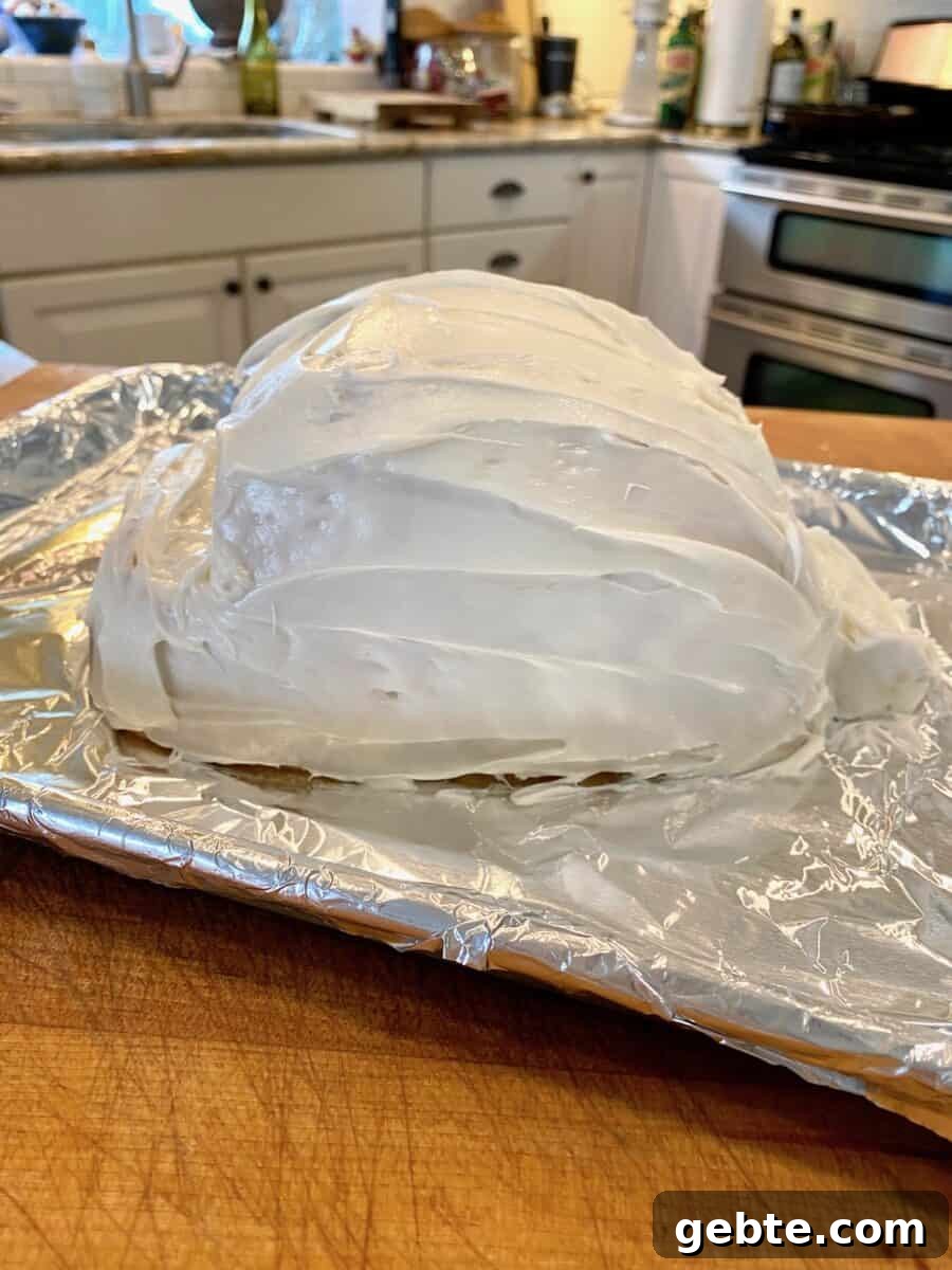 Frosted bunny cake on a foil baking sheet.