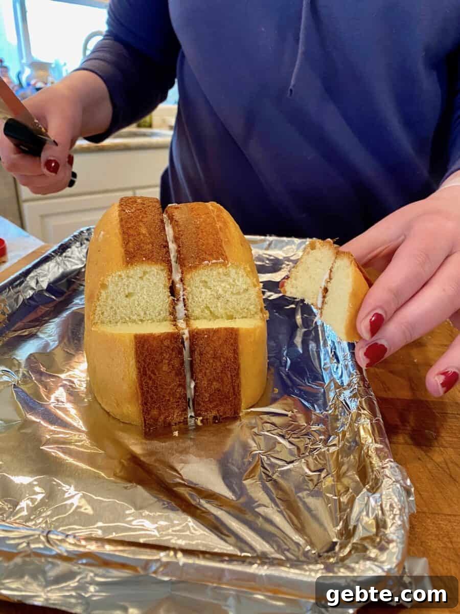 A wedge of cake cut from two baked cake rounds placed on a foil lined baking sheet.