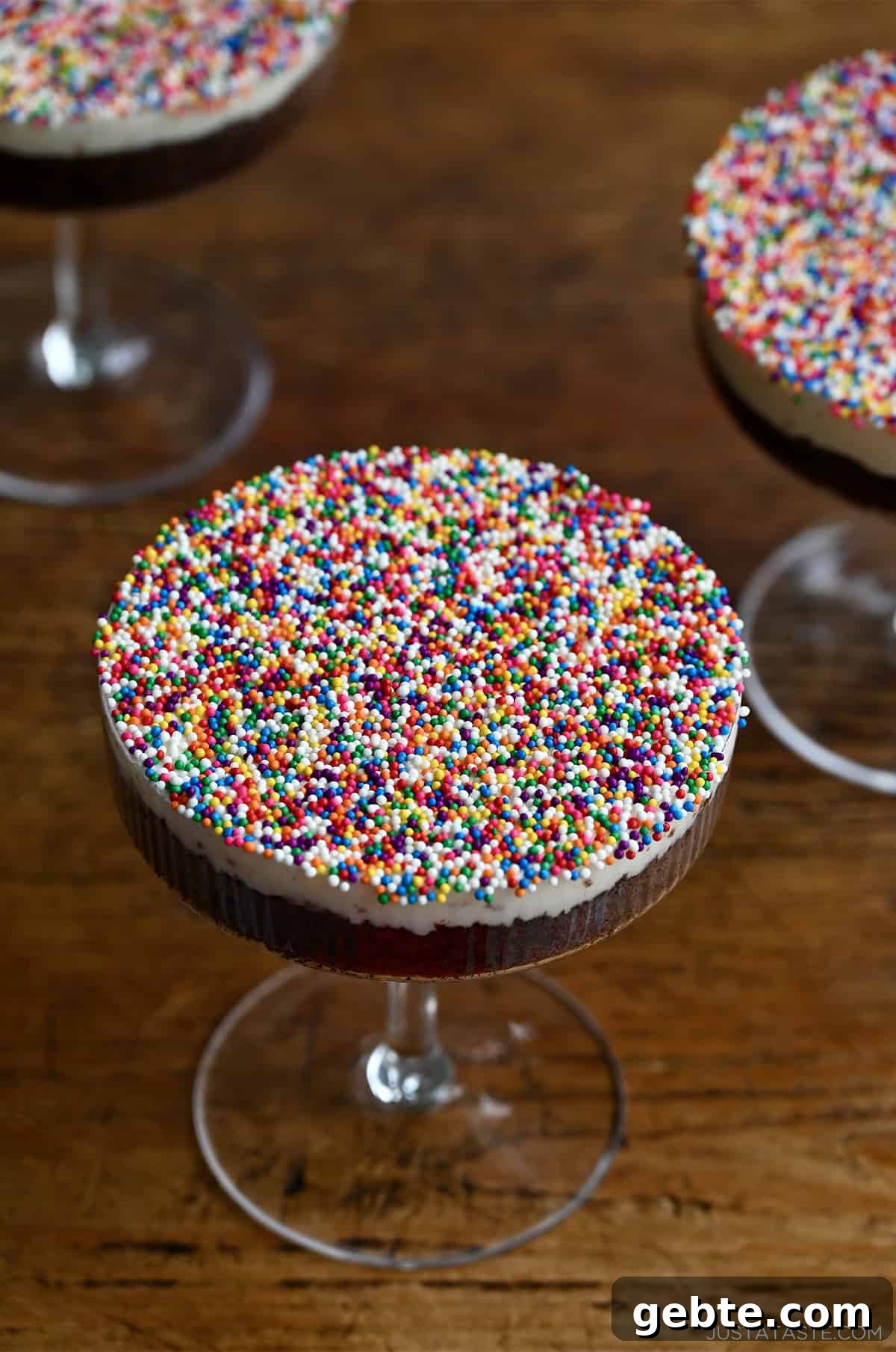 Homemade Polka Dot Cake Recipe 11 Cocktail dot cakes starring chocolate cake topped with vanilla buttercream frosting and a layer of rainbow sprinkles in a cocktail glass.