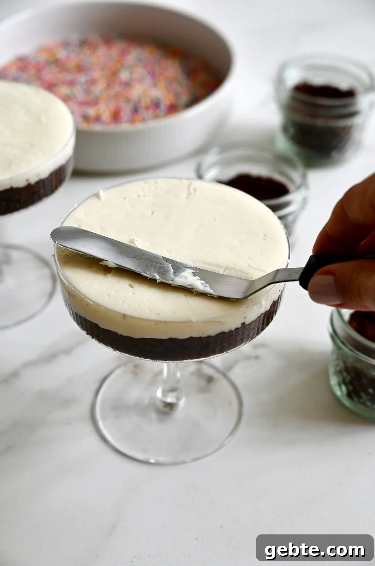 Homemade Polka Dot Cake Recipe 8 Using an offset spatula to frost an individual cake in a cocktail glass.
