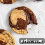 Chocolate marble cookies with flaky salt on parchment paper.