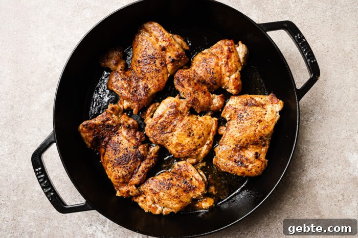Seared chicken thighs in a cast iron skillet.