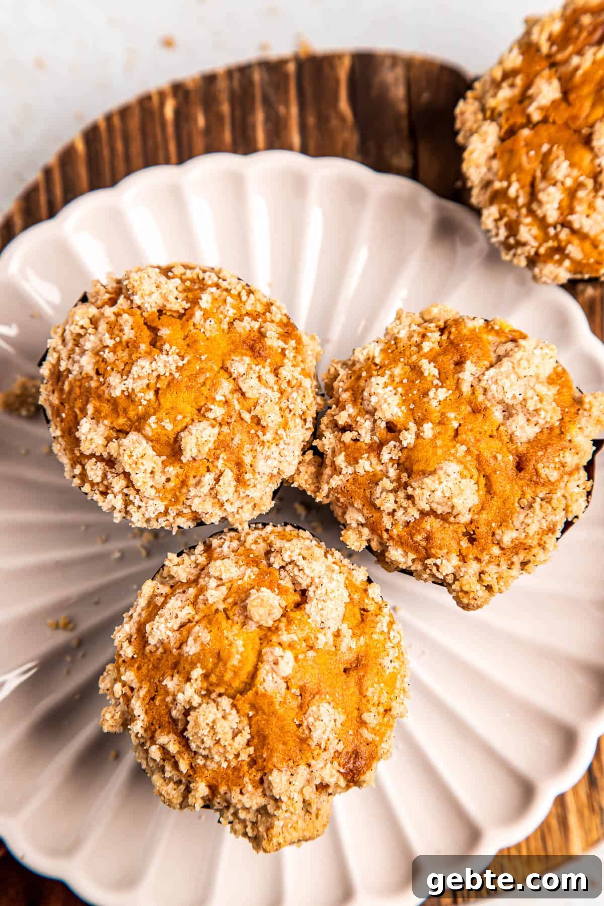 overhead shot of three pumpkin muffins on a white plate.