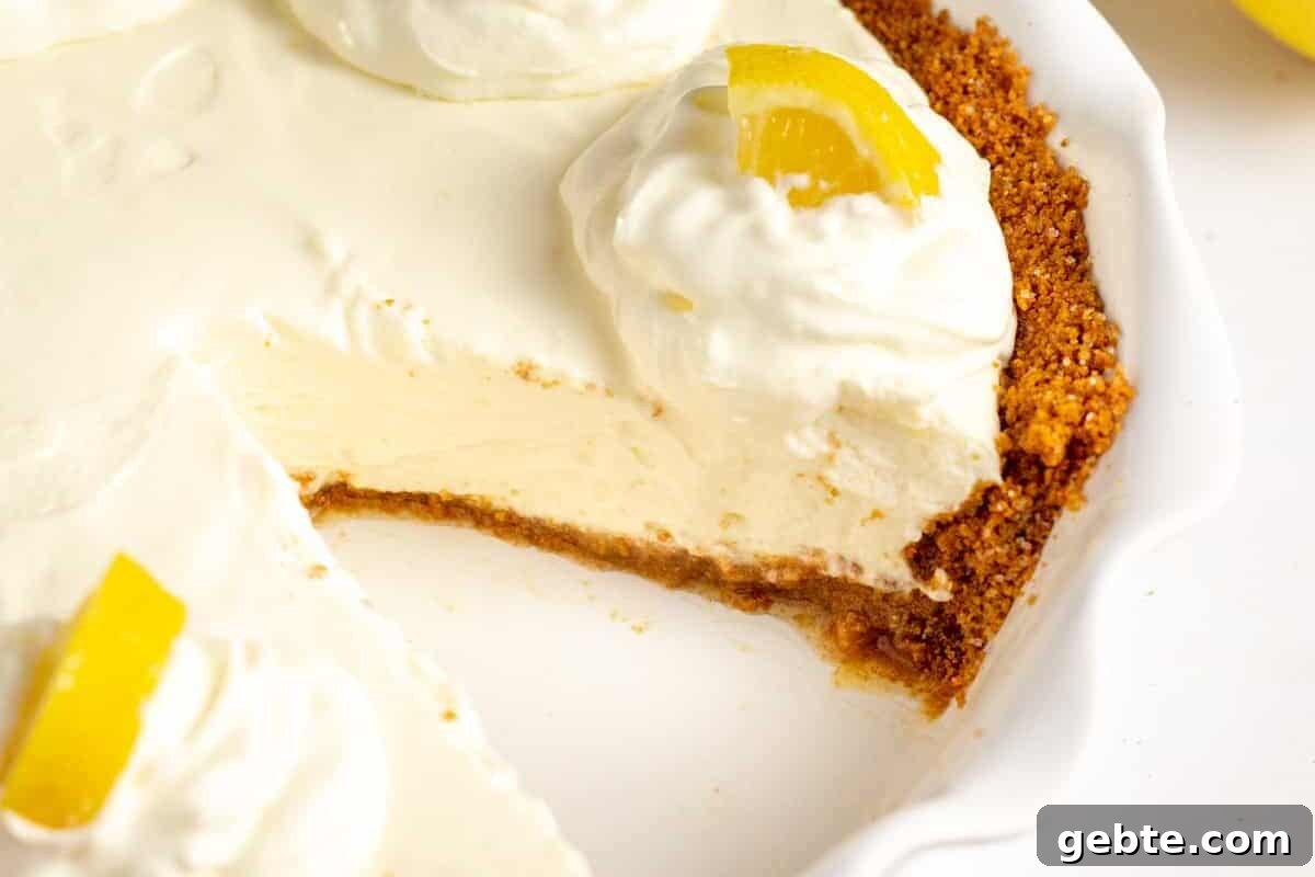 lemon cream pie with graham cracker crust served in a pie dish.