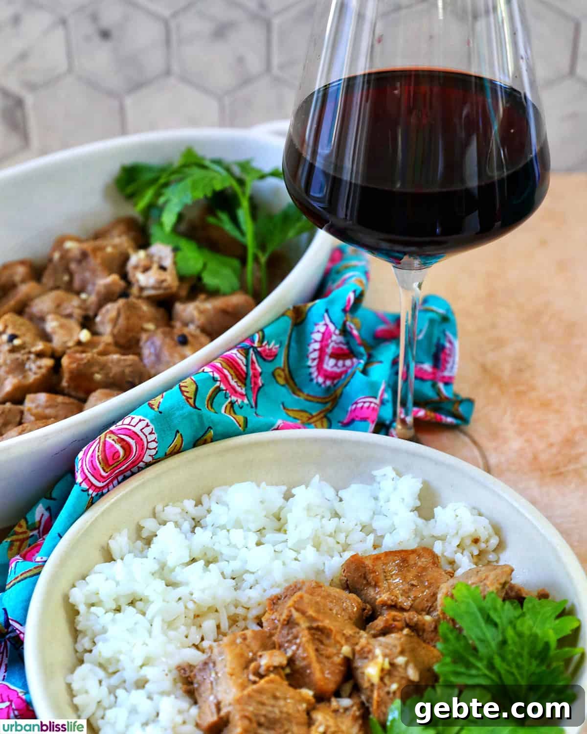 bowls of Filipino pork adobo with rice with glass of red wine.