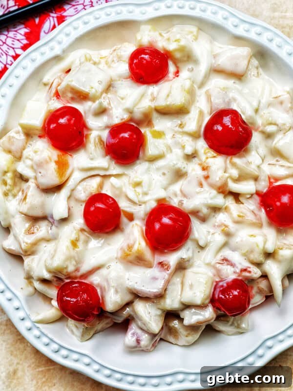 bowl of Filipino Fruit Salad topped with maraschino cherries.