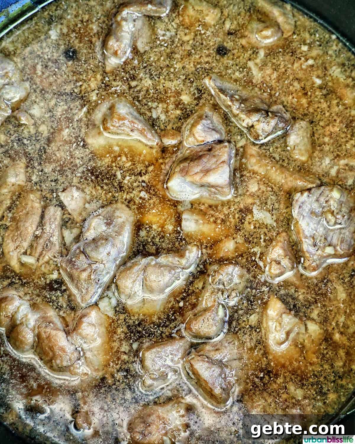 pork cooking in a pot with bay leaves.