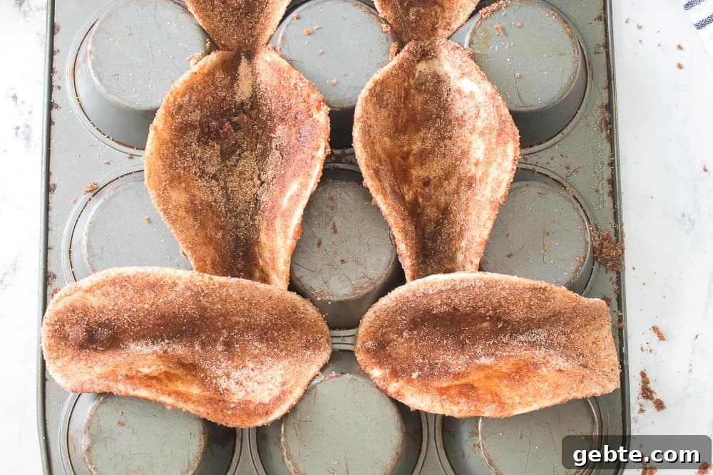taco shells coated with cinnamon and sugar on an upside down muffin pan