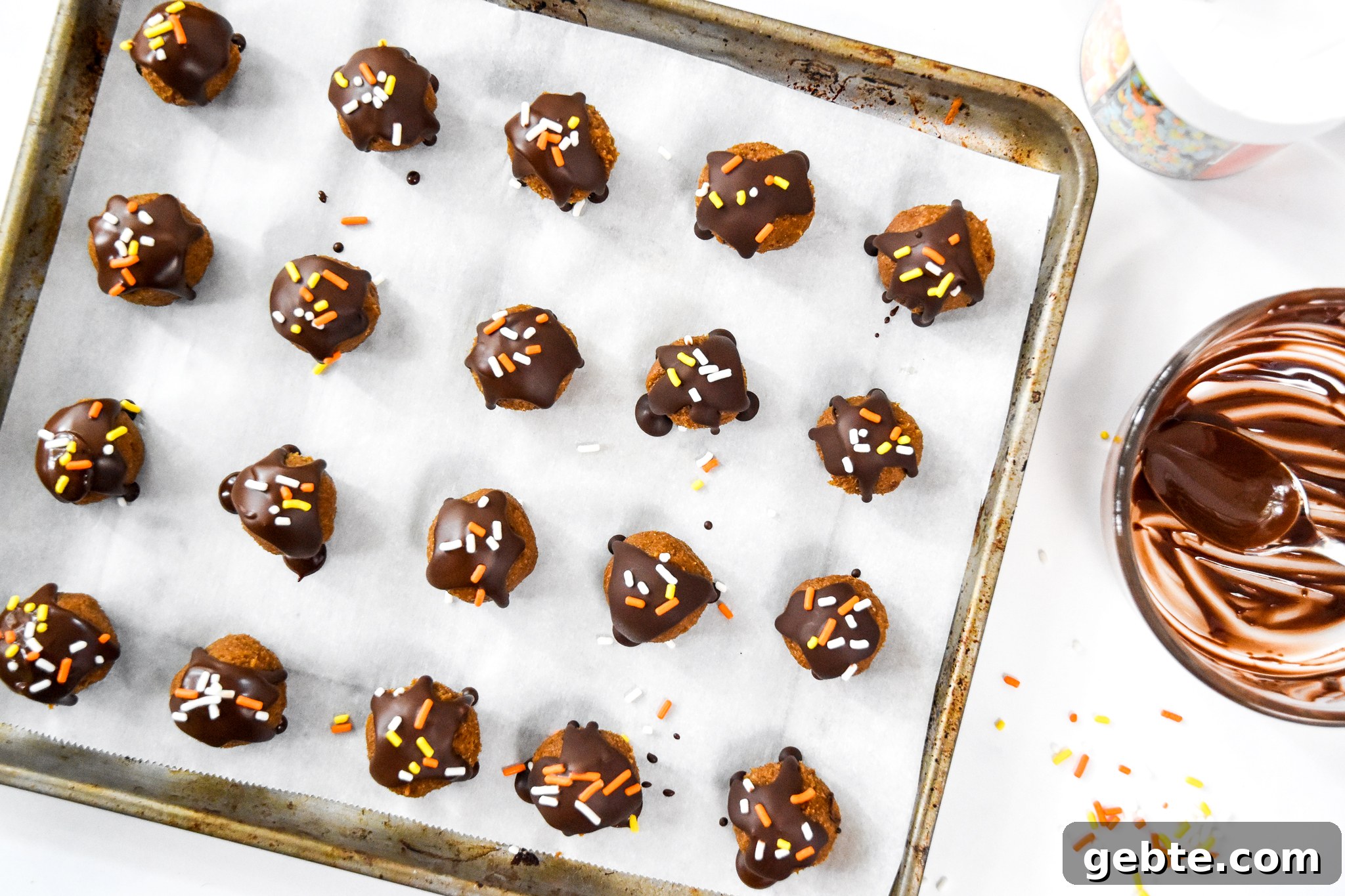 No-Bake Pumpkin Pie Date Balls: Fall Snack Recipe 9 no-bake pumpkin spice date balls on a parchment lined baking sheet.