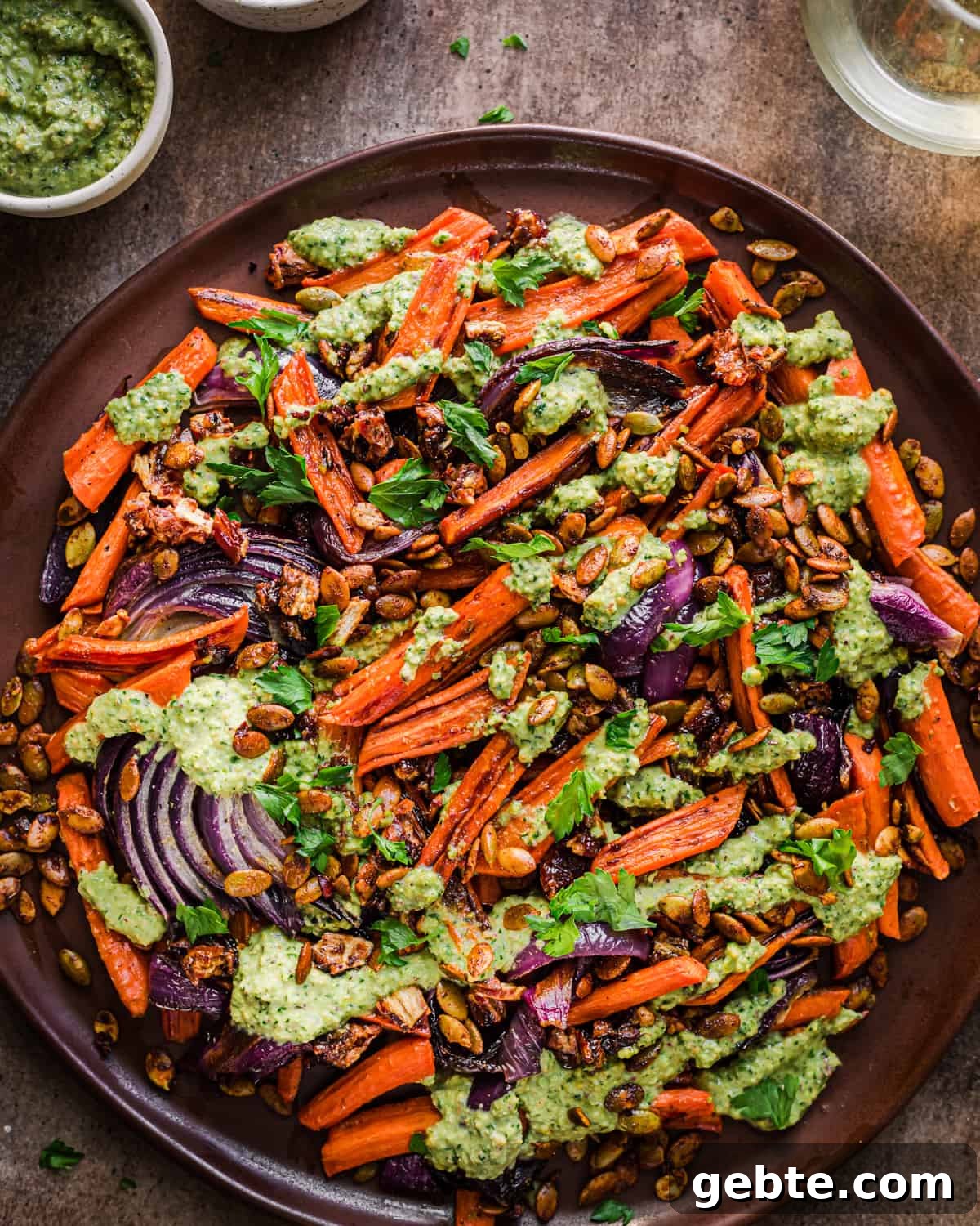 Oven-Roasted Carrots and Dates with Pistachio Pesto 15 Finished carrot and date dish on a brown plate.