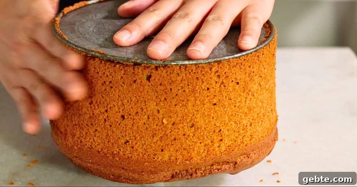 removing freshly baked pumpkin spice chiffon cake from the pan