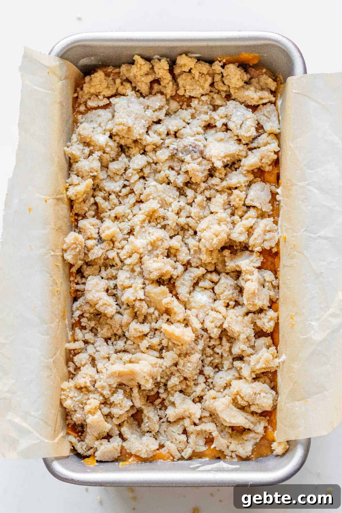 Pumpkin Cream Cheese Swirl Bread 7 pumpkin bread batter with a streusel topping in a loaf pan