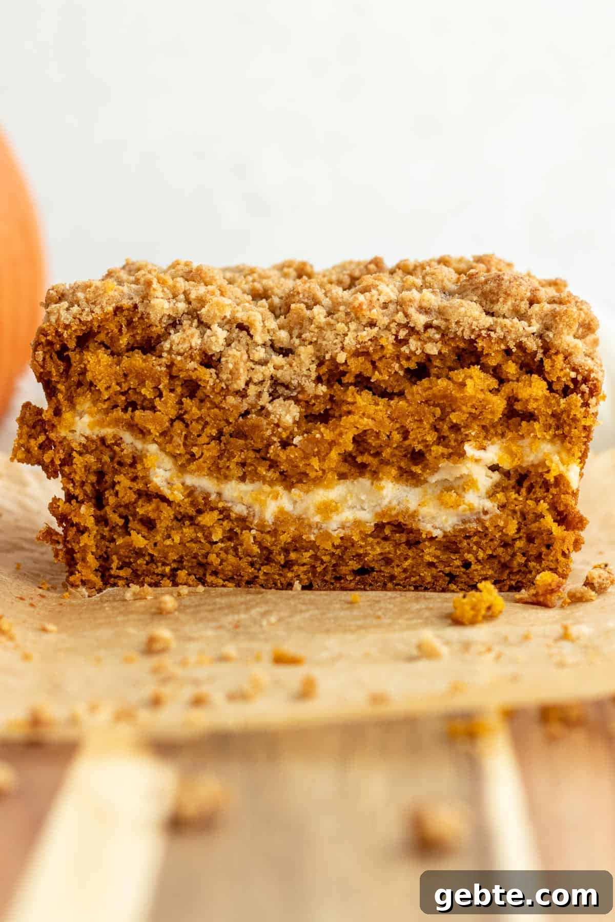 Pumpkin Cream Cheese Swirl Bread 8 close up of a loaf of pumpkin cream cheese bread cut into showing layer of cream cheese in the bread