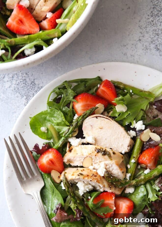 Two plates of strawberry asparagus salad with chicken 