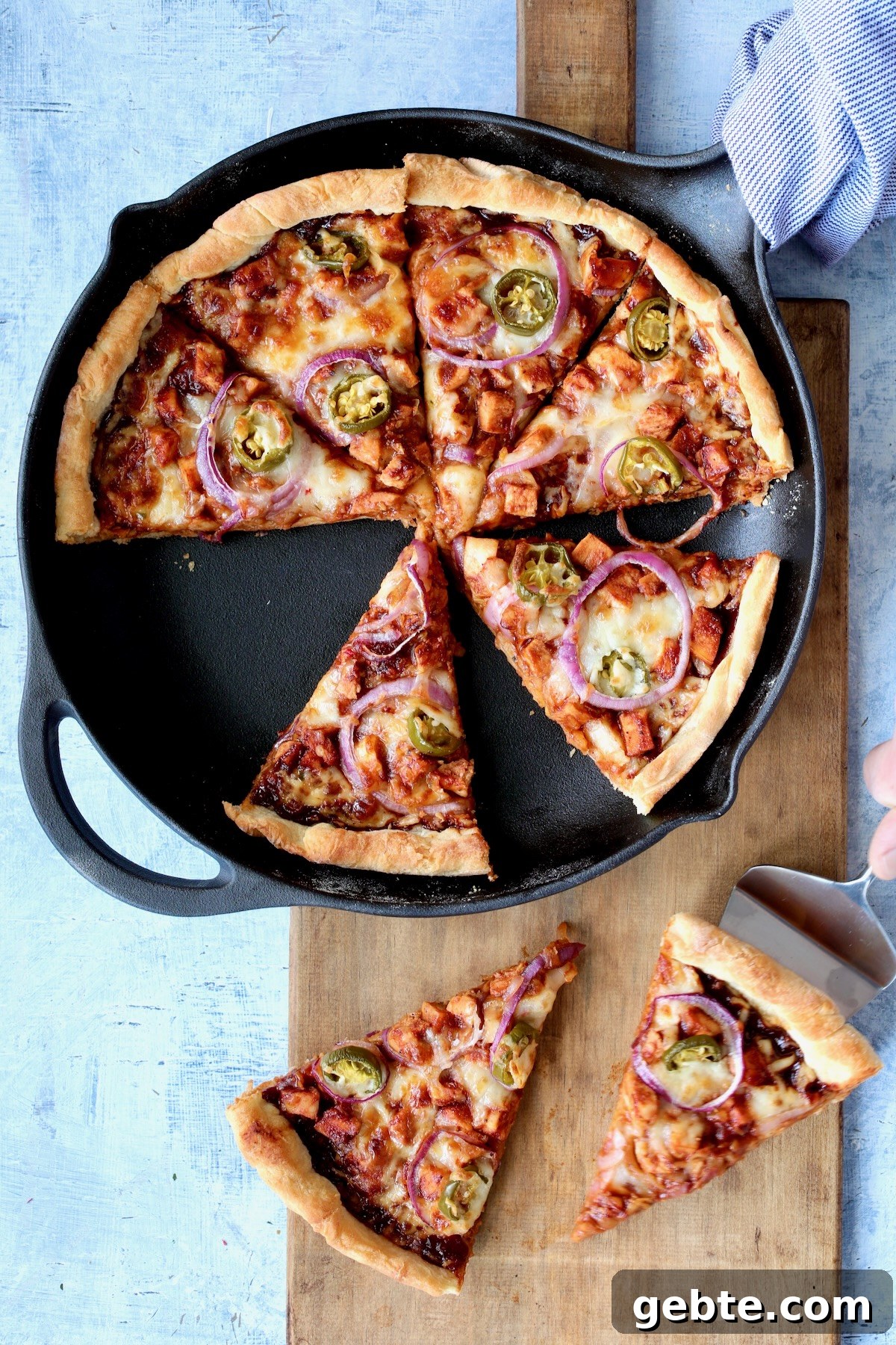 Crispy Cast Iron Skillet Pizza with Cheesy Crust 5 Topped pizza in cast iron skillet after being baked and cut into wedges.