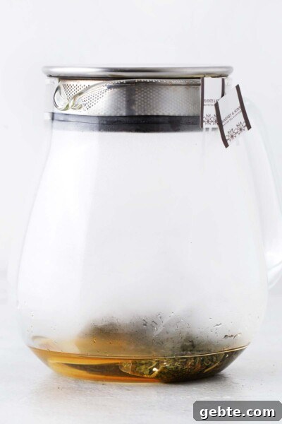 Pineapple Iced Tea Recipe — Tropical Summer Drink 6 Green tea bags steeping in teapot with lid.
