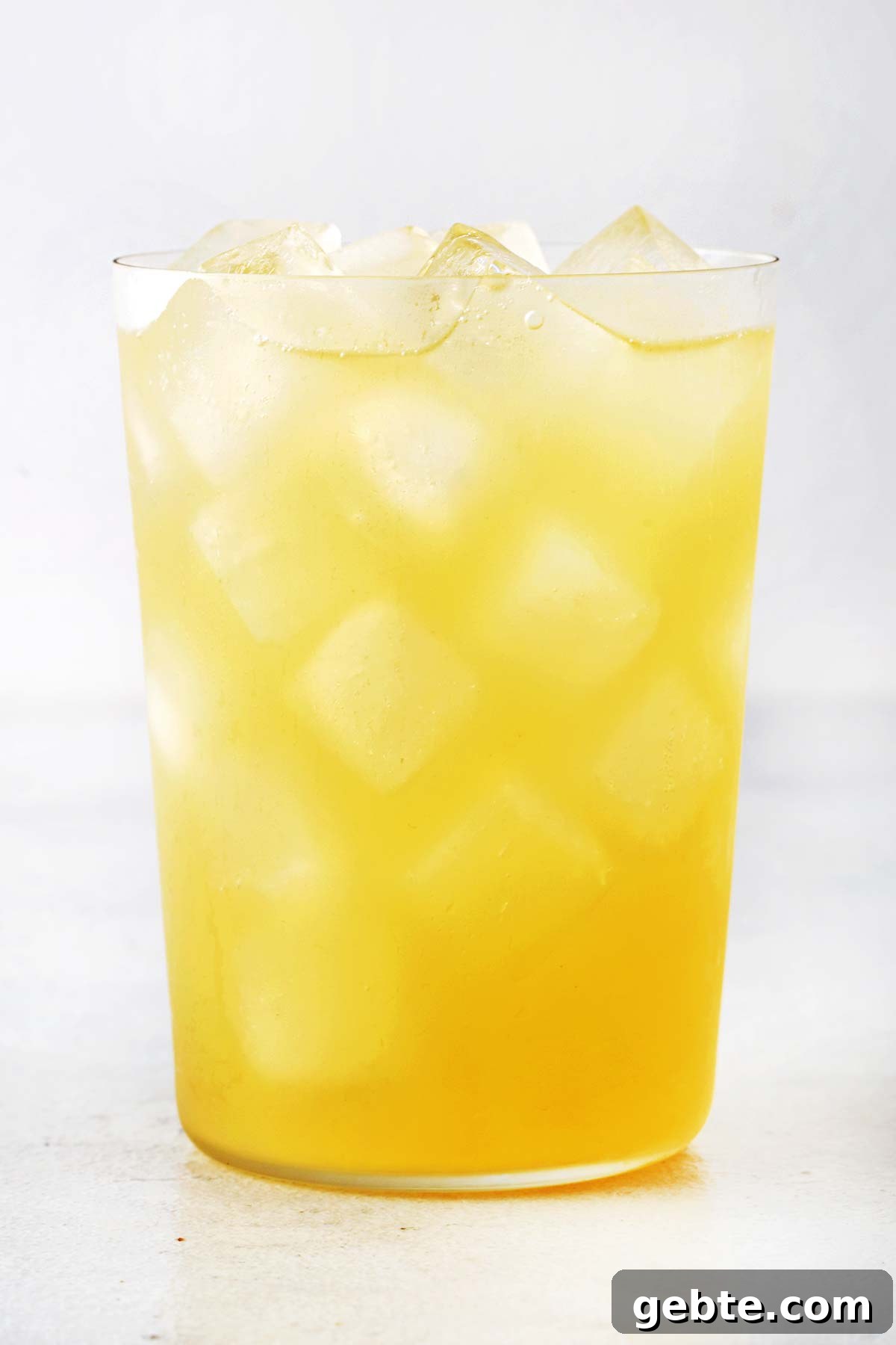 Pineapple Iced Tea Recipe — Tropical Summer Drink 9 Pineapple iced tea in a cup.