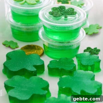 A white rectangle platter with green jello shots and jigglers shaped like shamrocks.