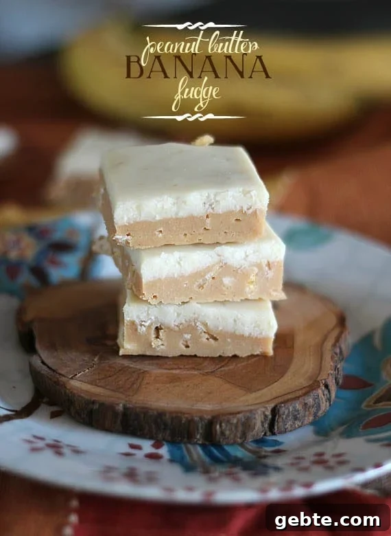 Three squares of Peanut Butter Fudge stacked on a wooden slice