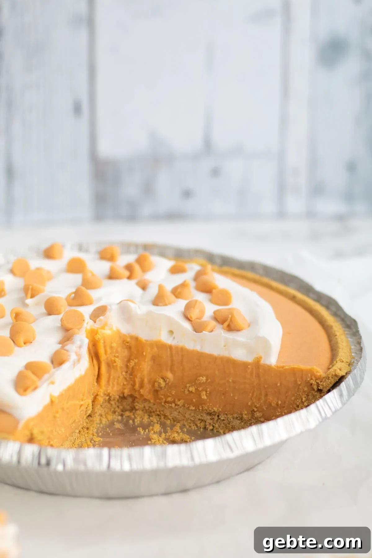 butterscotch pudding pie with a slice taken out.
