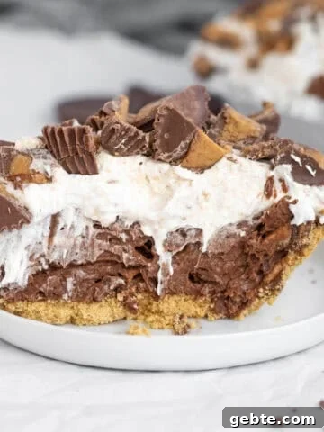 chocolate peanut butter cup pudding pie on a white plate.
