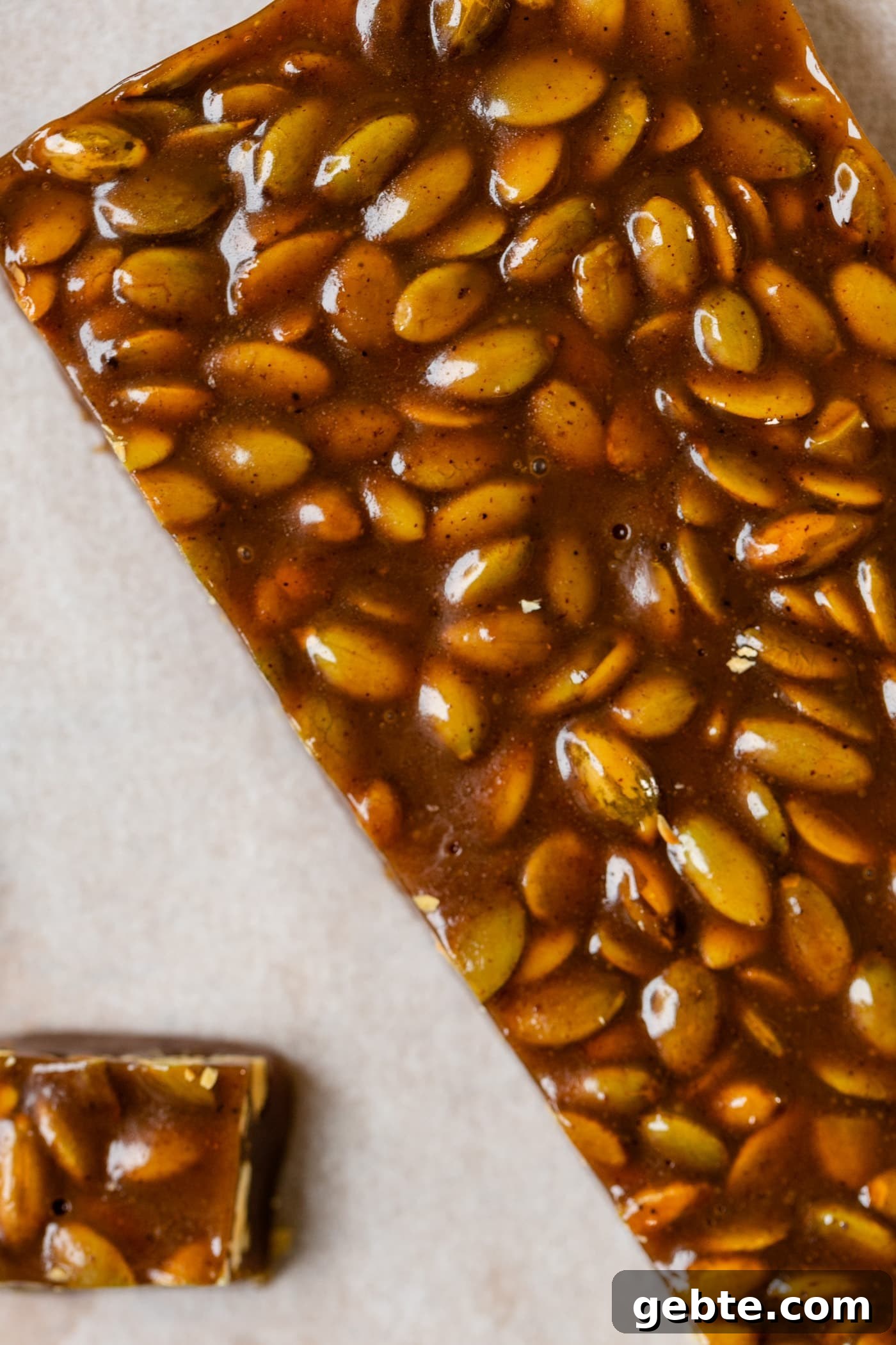 Top down view of bar to be cut into pumpkin spice caramels sitting on piece of white parchment paper