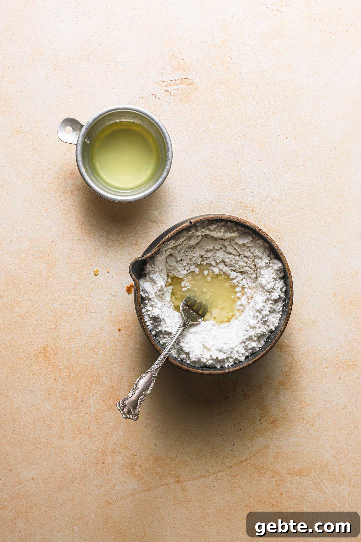 A bowl with powdered sugar and lemon juice. A cup with lemon juice.