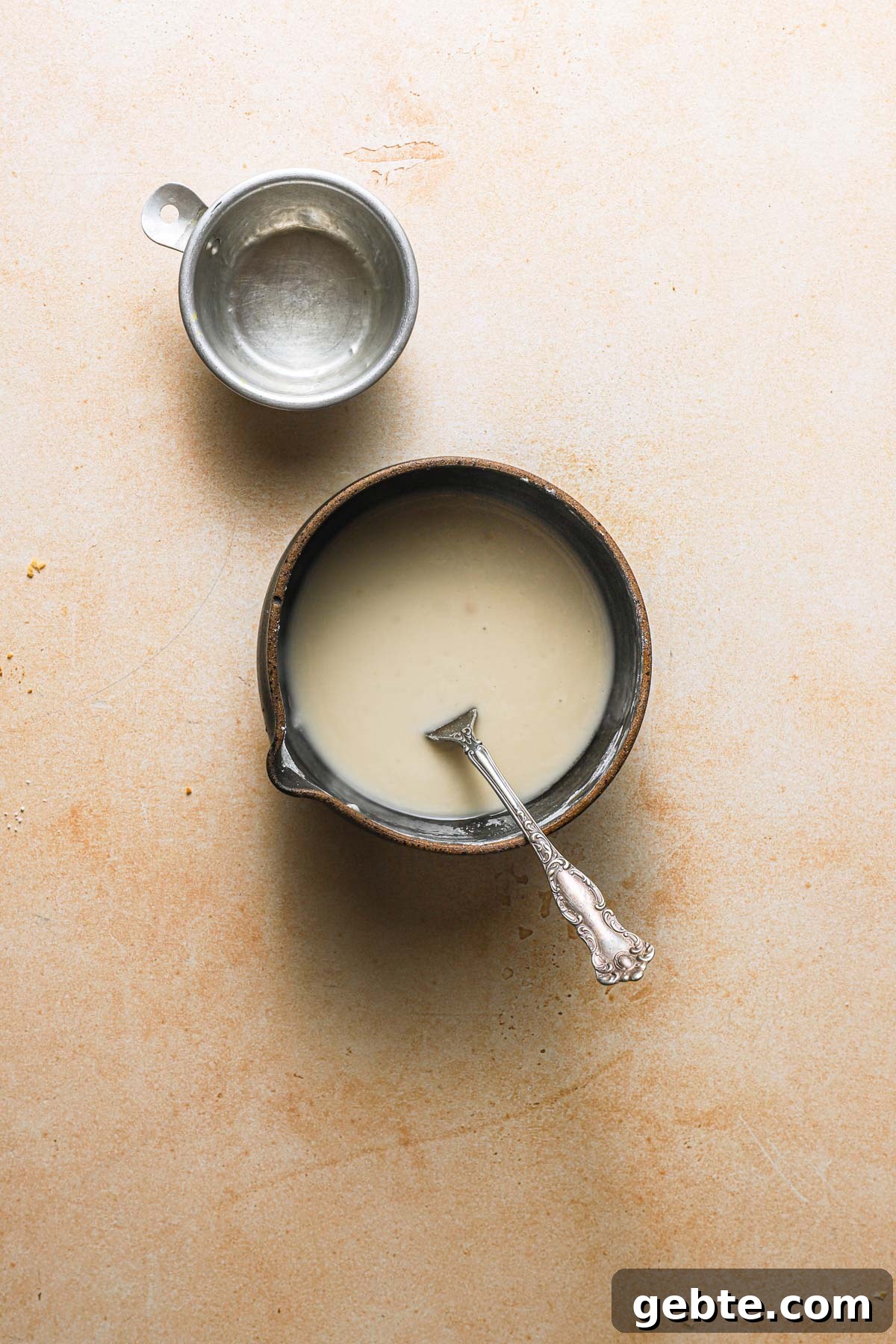A bowl with lemon glaze and an empty cup.