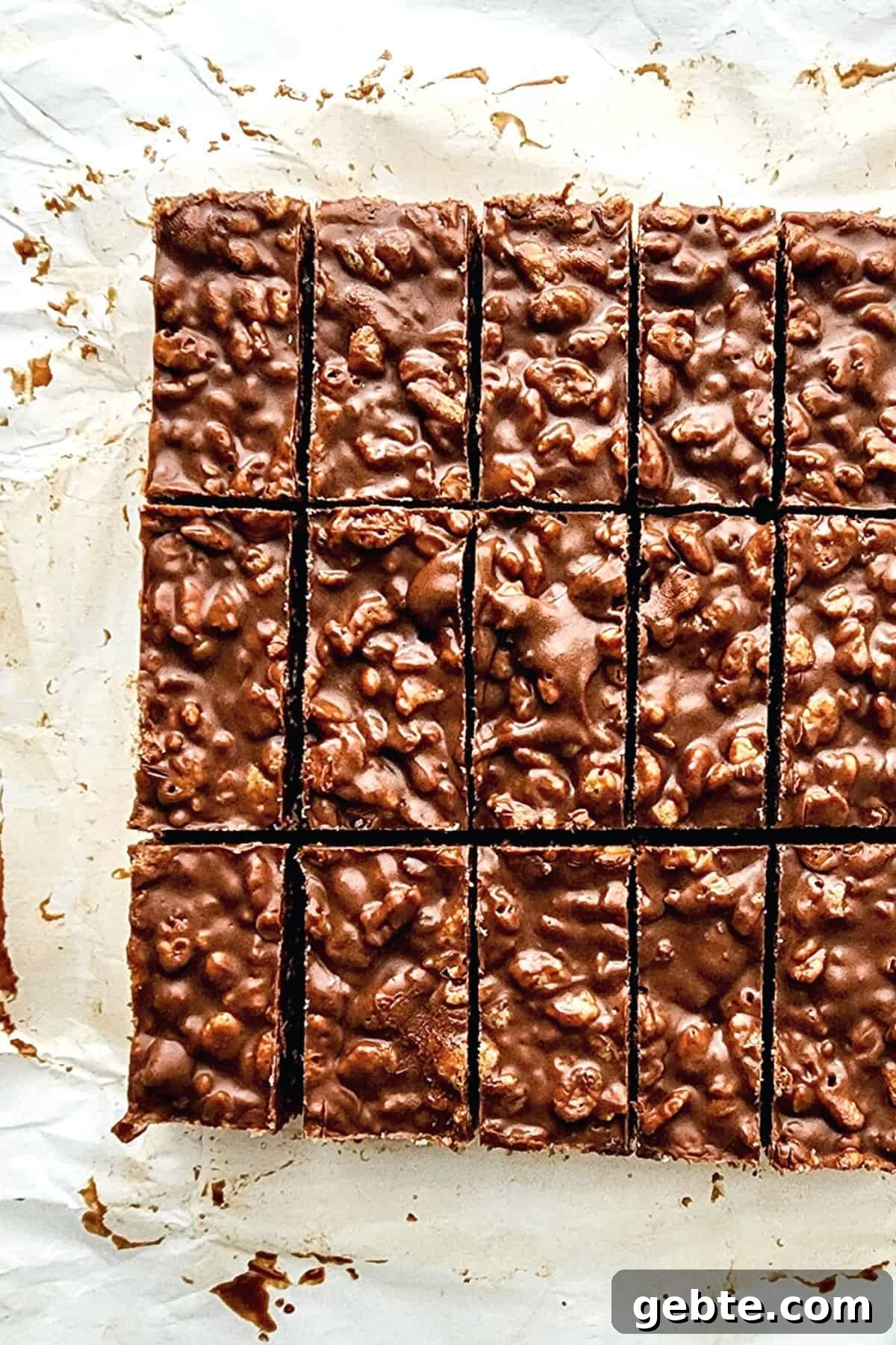 Sliced pieces of peanut butter crunch bars on parchment paper.
