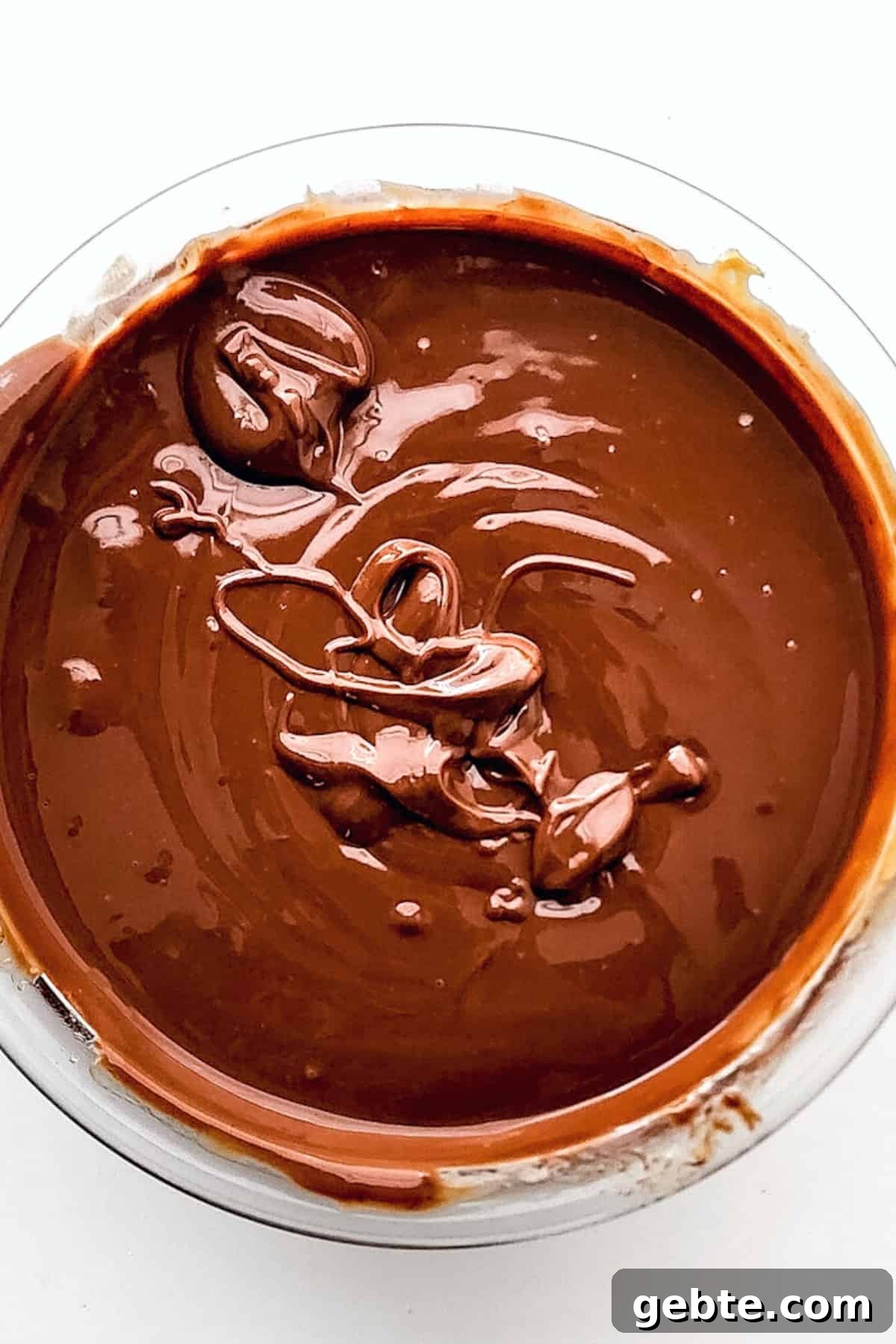 Glossy chocolate mixture in large glass bowl.