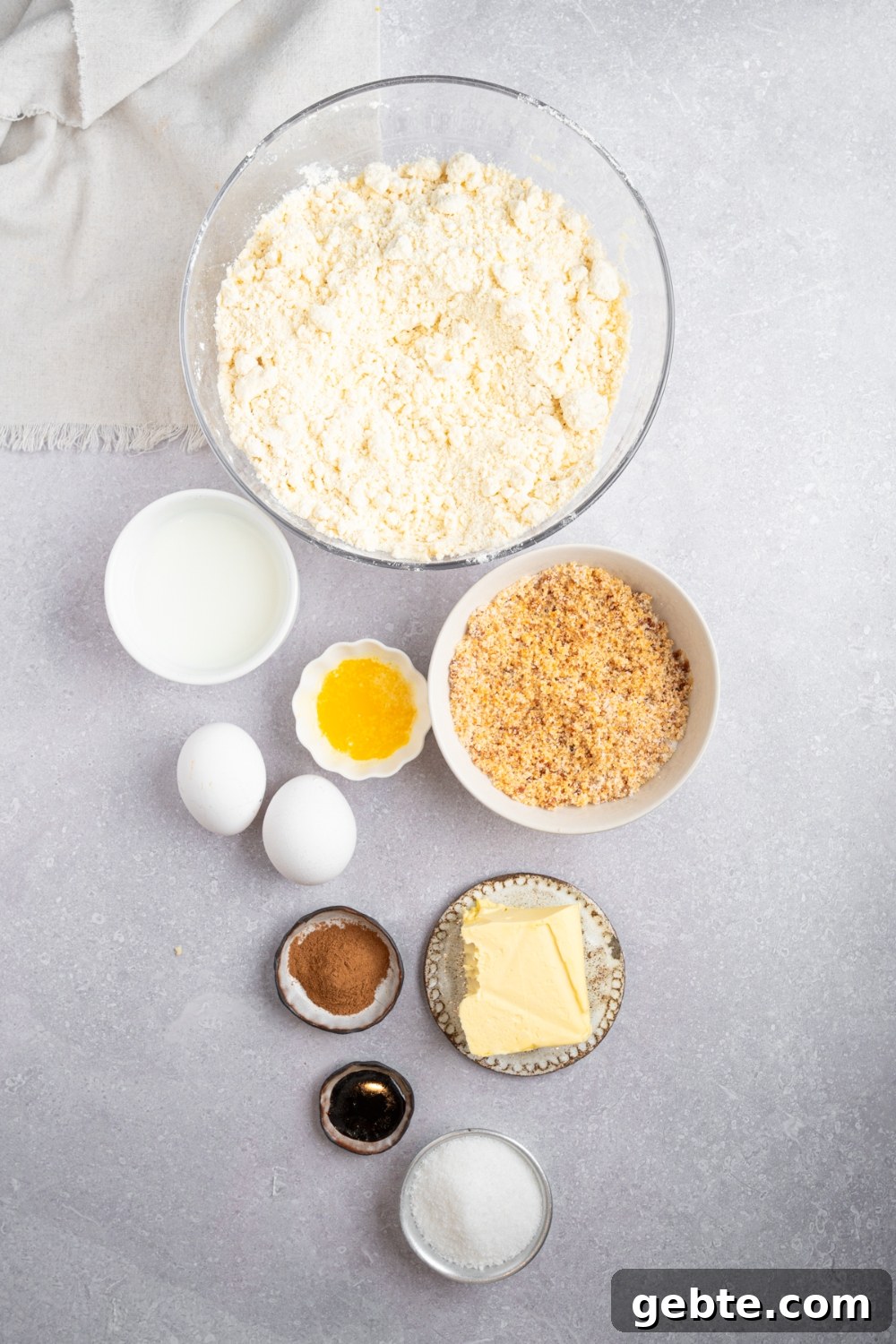 An overhead shot of several bowls in various sizes containing ingredients to make Bisquick coffee cake including Bisquick mix, sugar, milk, eggs, vanilla, cinnamon, butter, and brown sugar.