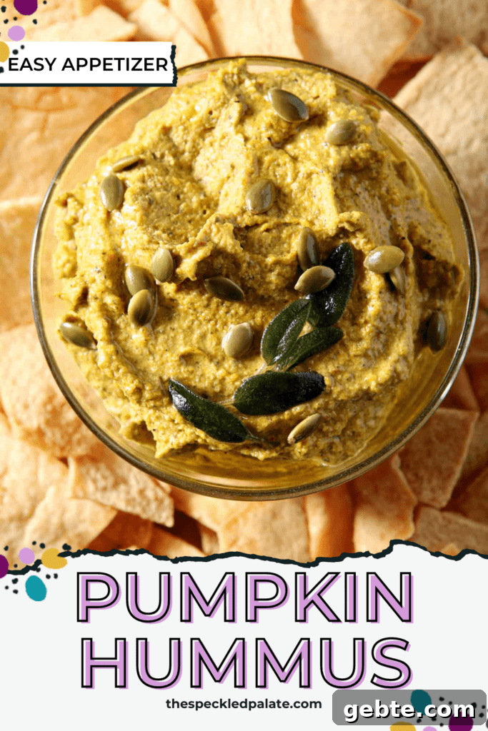 fall hummus in a glass jar on a plate surrounded by pita chips with the text pumpkin hummus
